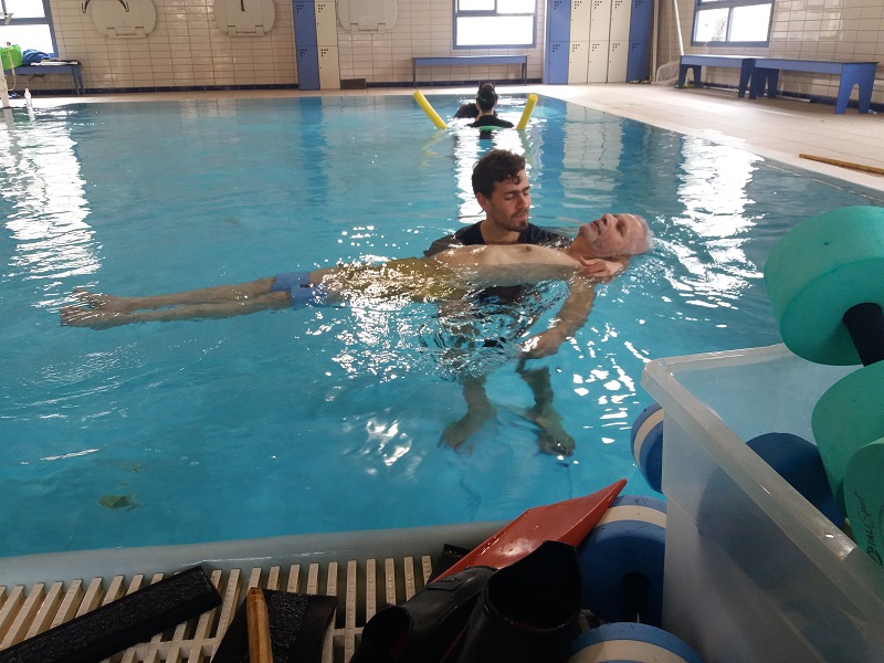 המטפל יואב בן -צבי עם המטופל אלי פורת בבריכה הטיפולית של חוויות (צילום: מוטי שודריך)