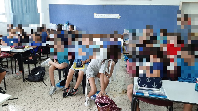 תלמידים בבית הספר ויצמן יושבים על כיסאות פלסטיק ללא שולחנות