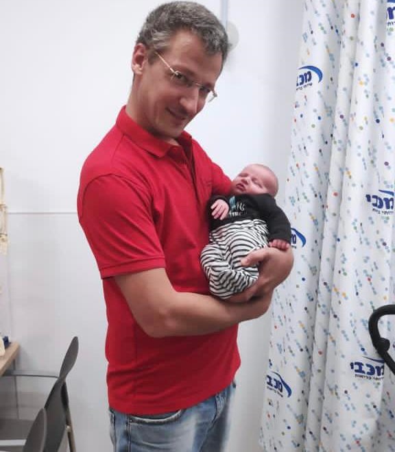 ד"ר ינאי זינס מחזיק את התינוק ינאי שנקרא על שמו (צילום: מכבי שירותי בריאות)